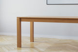 A handmade modern minimalist wooden dining table with square legs in an architectural style made from cherry wood.
