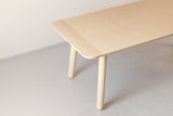 A handmade danish modern solid wood dining table with round legs in ash
