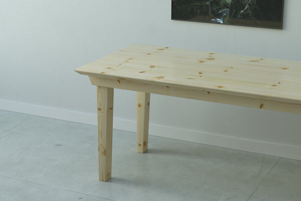 A handmade modern farmhouse style wooden dining table from solid pine wood.