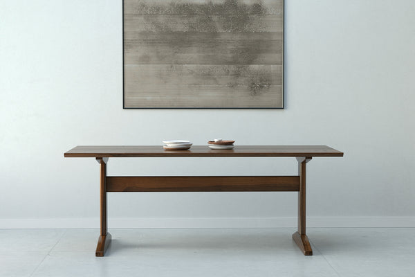 A handmade modern farmhouse style wooden dining table from solid walnut wood.