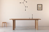 A handmade Japanese solid wood dining table with rectangular legs in an architectural minimalist style made from oak.