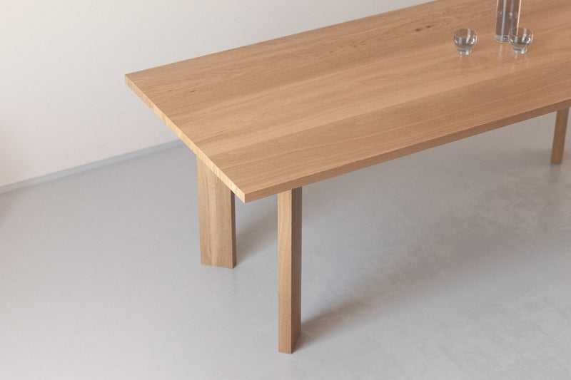 A handmade Japanese solid wood dining table with rectangular legs in an architectural minimalist style made from oak.