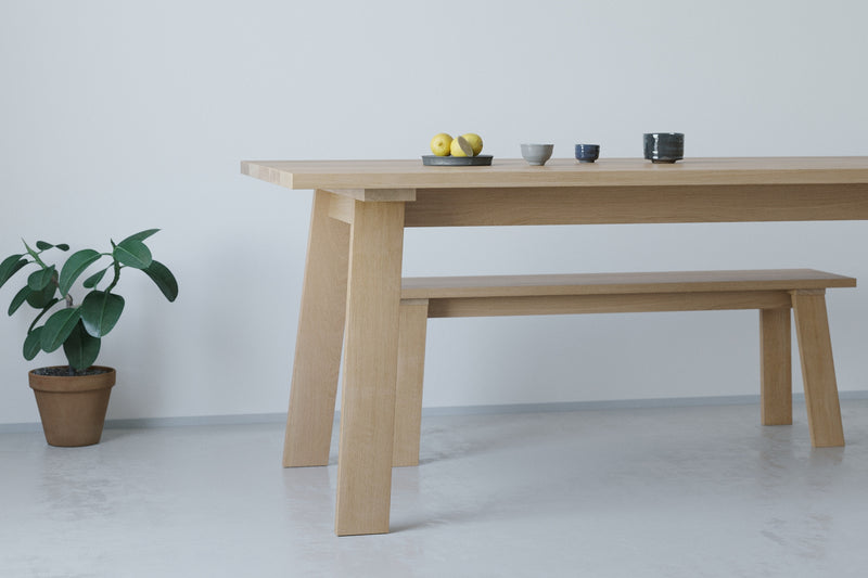 A handmade Japanese solid wood dining table with trestle base in an architectural minimalist style made from oak.