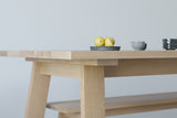 A handmade Japanese solid wood dining table with trestle base in an architectural minimalist style made from oak.