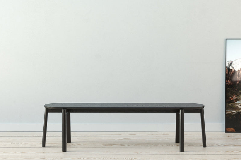 A handmade Scandinavian minimalist designed wooden bench with turned round legs made from solid ash wood stained black.