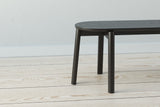 A handmade Scandinavian minimalist designed wooden bench with turned round legs made from solid ash wood stained black.